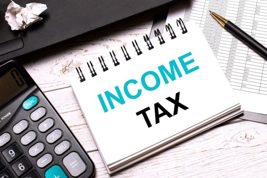 lightcolored-office-table-is-computer-black-calculator-pen-notebook-with-text-income-tax-busine